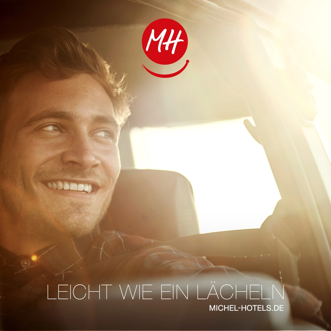 Michel Hotels Social Media Sommerkampagne, Leicht wie ein Laecheln, Foto junger laechelnder Mann im Auto mit Sonnenlicht